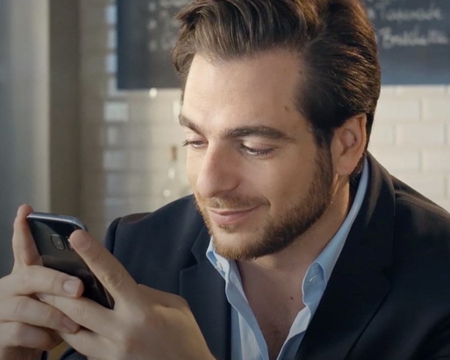 Homme sur son smartphone au café